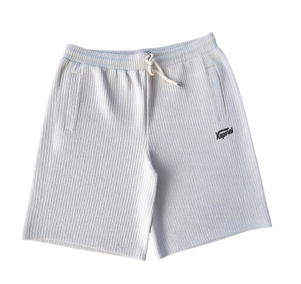 Klothco Kaporal white textured drawstring shorts with vertical ribbing and small black logo embroidery.